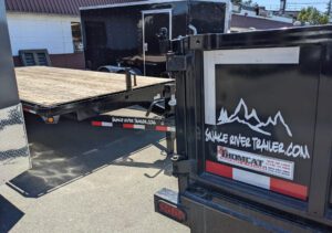 A closeup view of an assortment of trailers included flat bed, dump trailer, and cargo trailer